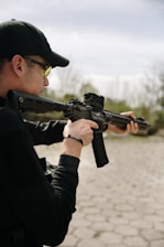 Man aims a rifle towards a distant target.