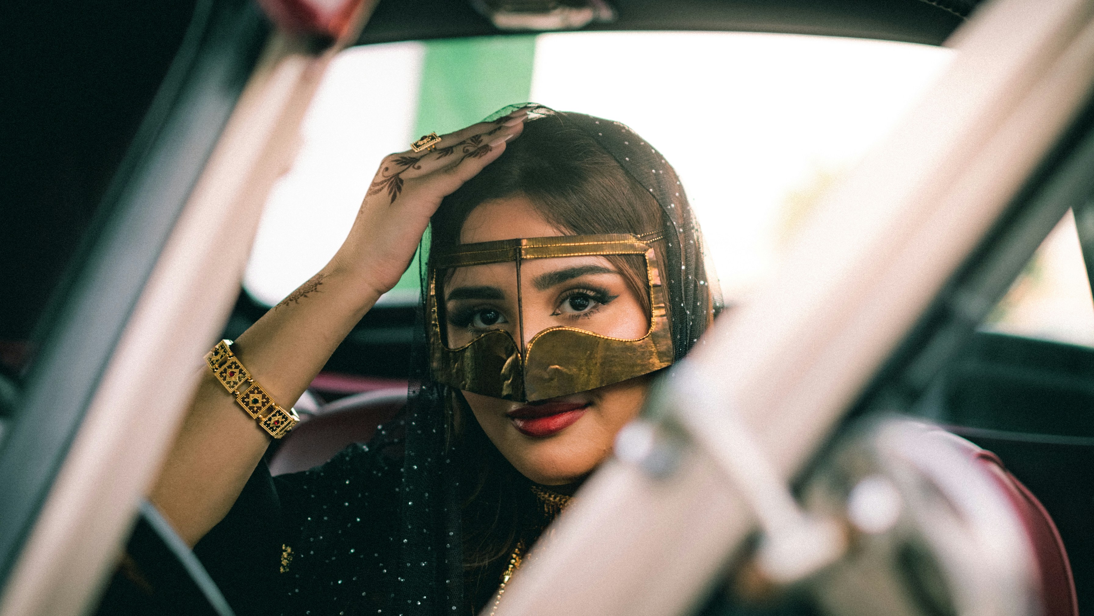 A woman wears traditional gold face coverings.