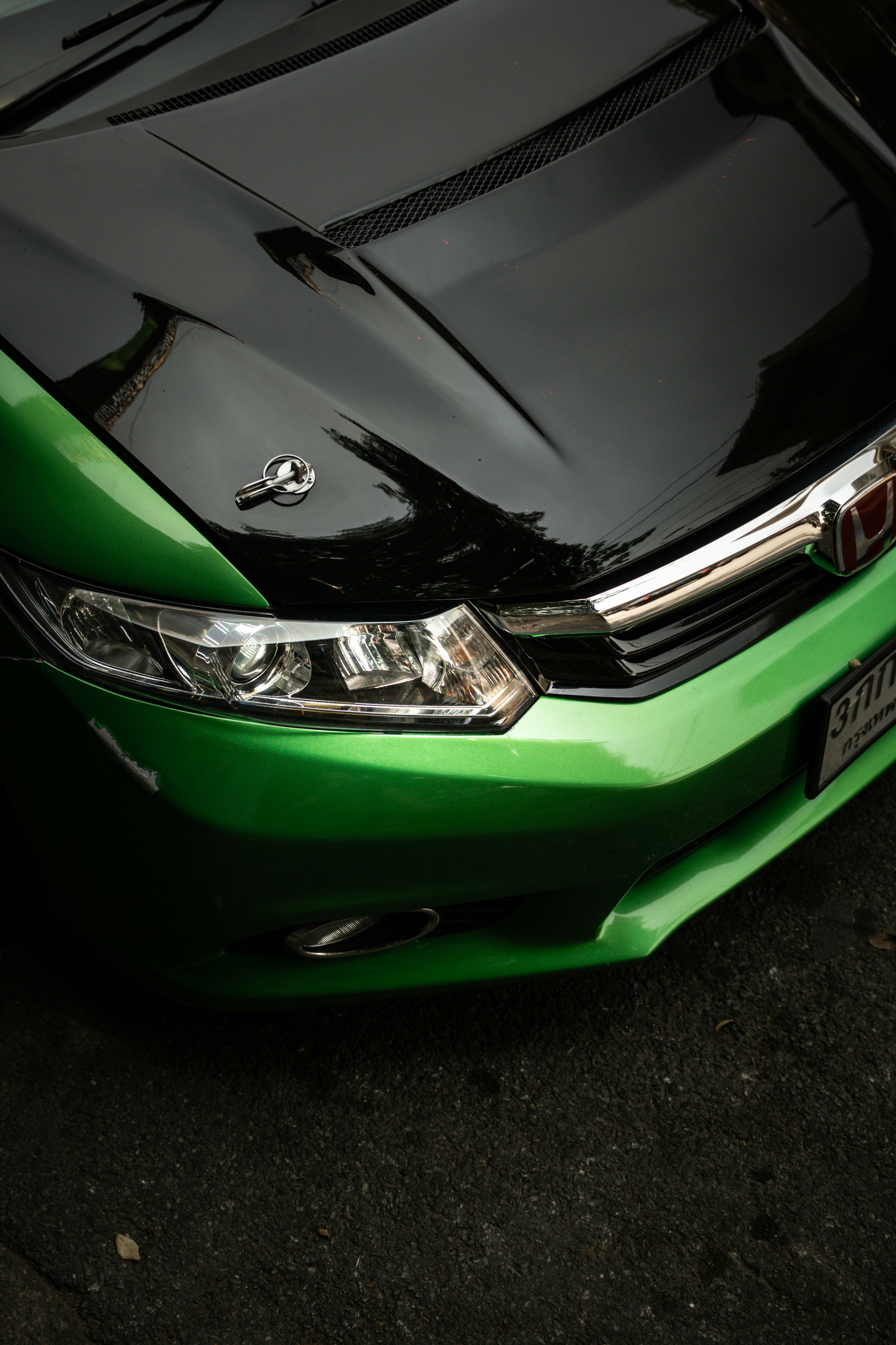 A green car with a black hood is shown.