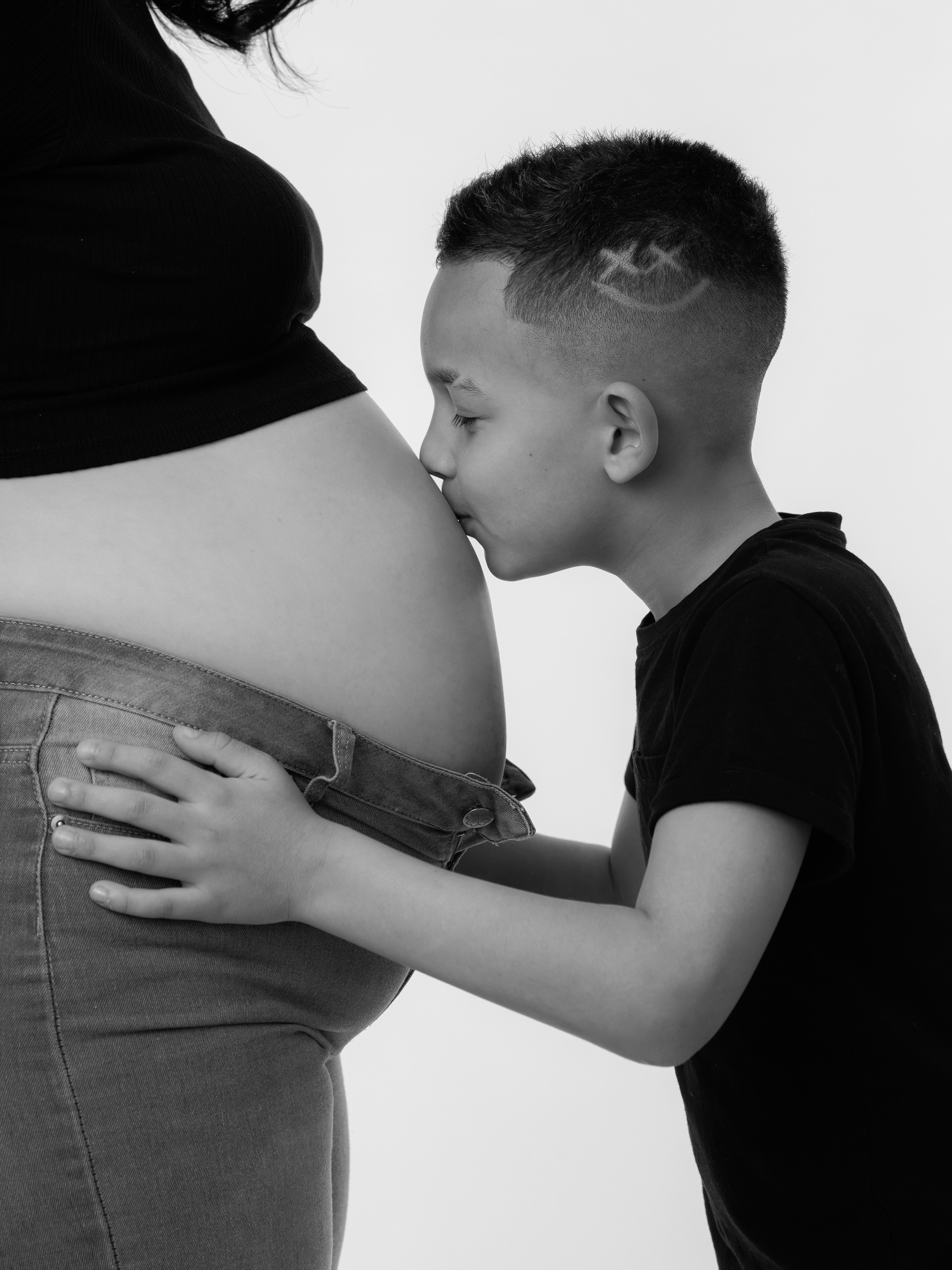 Boy kisses his mother's pregnant belly