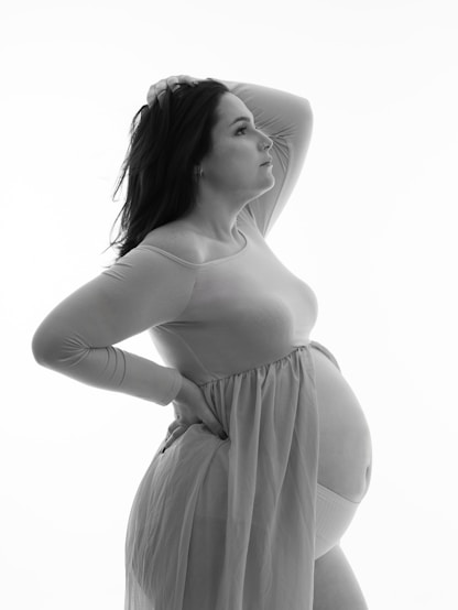 Pregnant woman poses in a graceful, ethereal way.