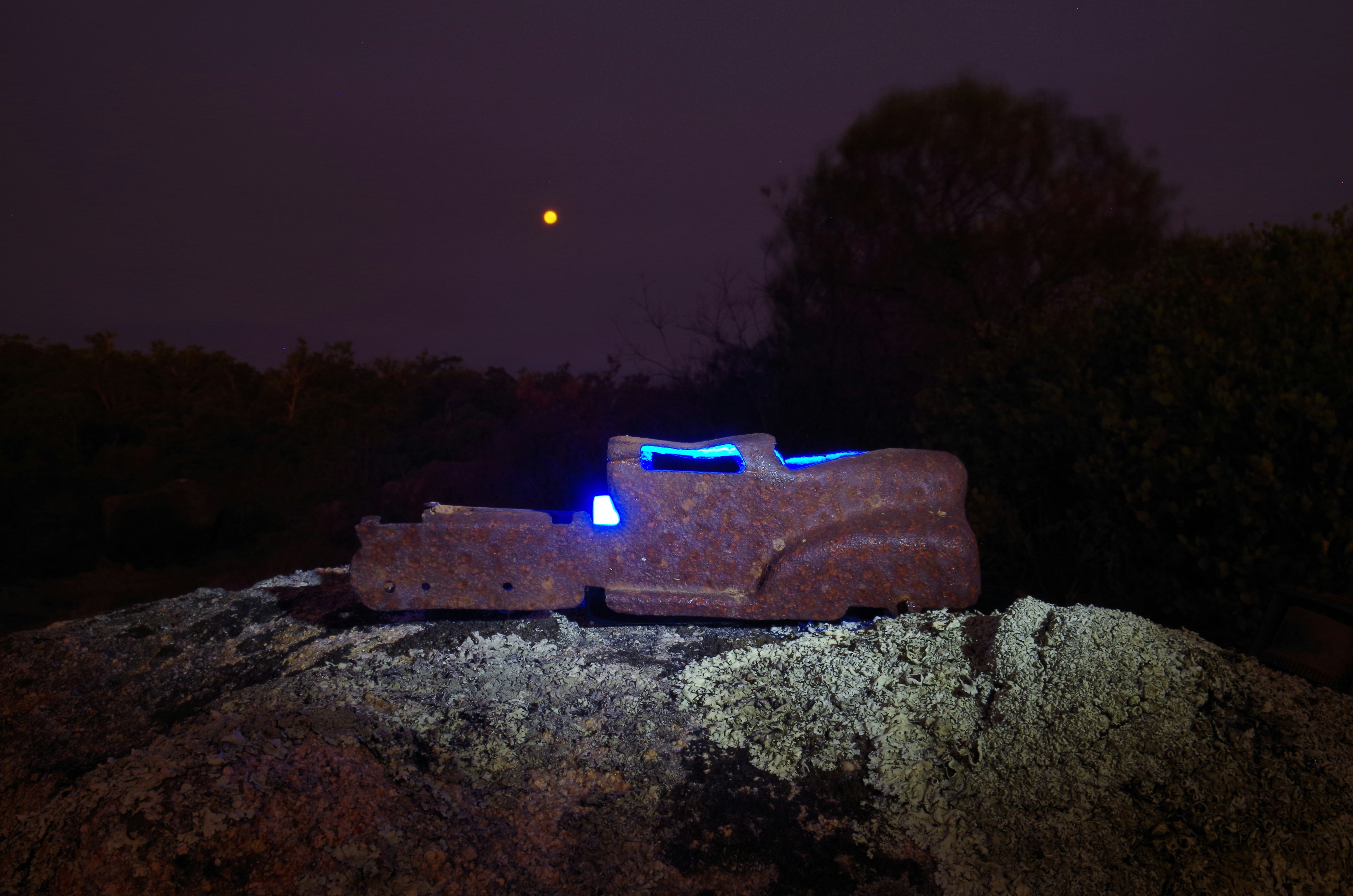A lighted car sculpture at night.