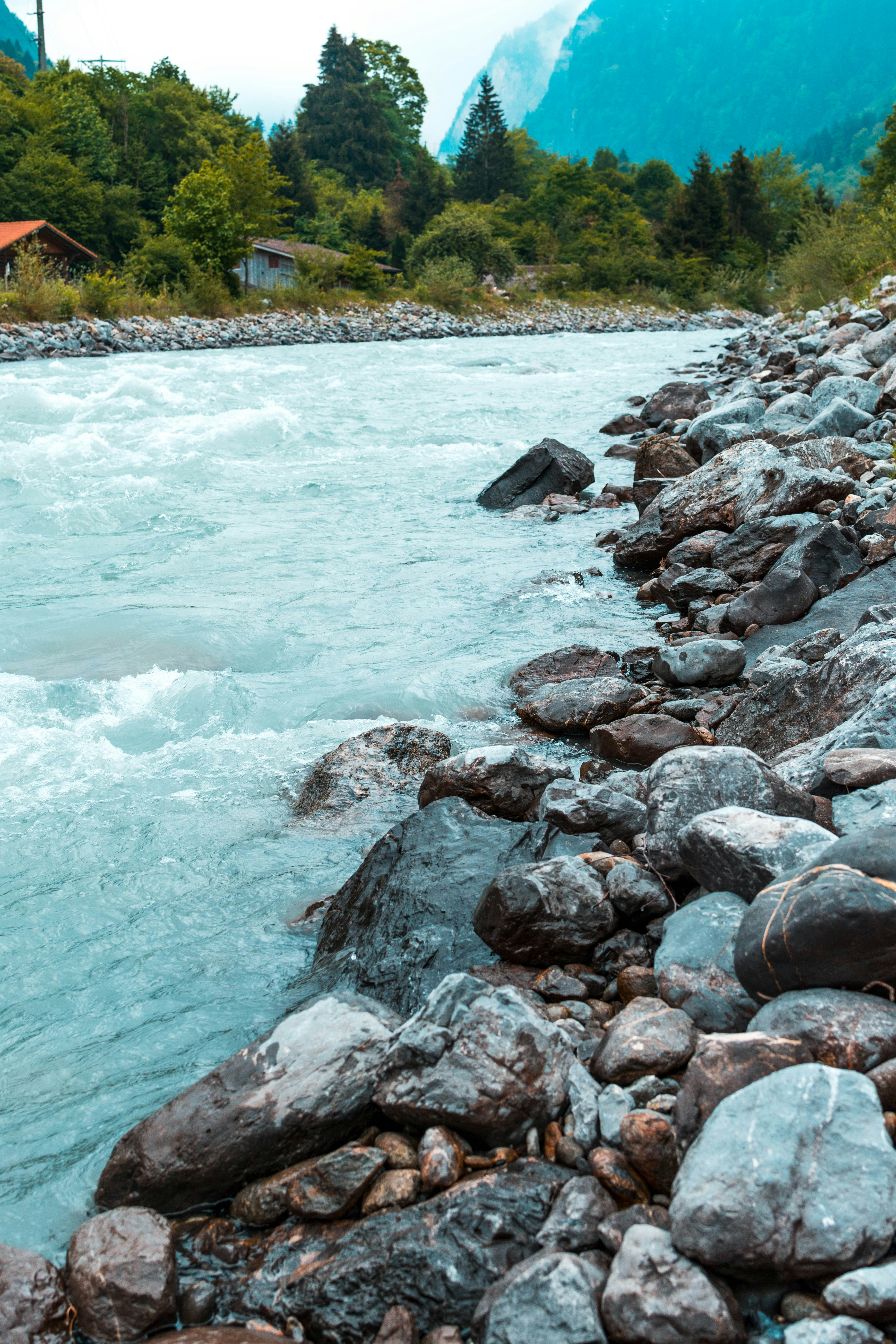 A river flows through rocky shores and mountains.