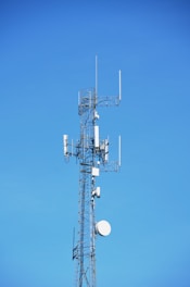 A telecommunication tower against a blue sky.