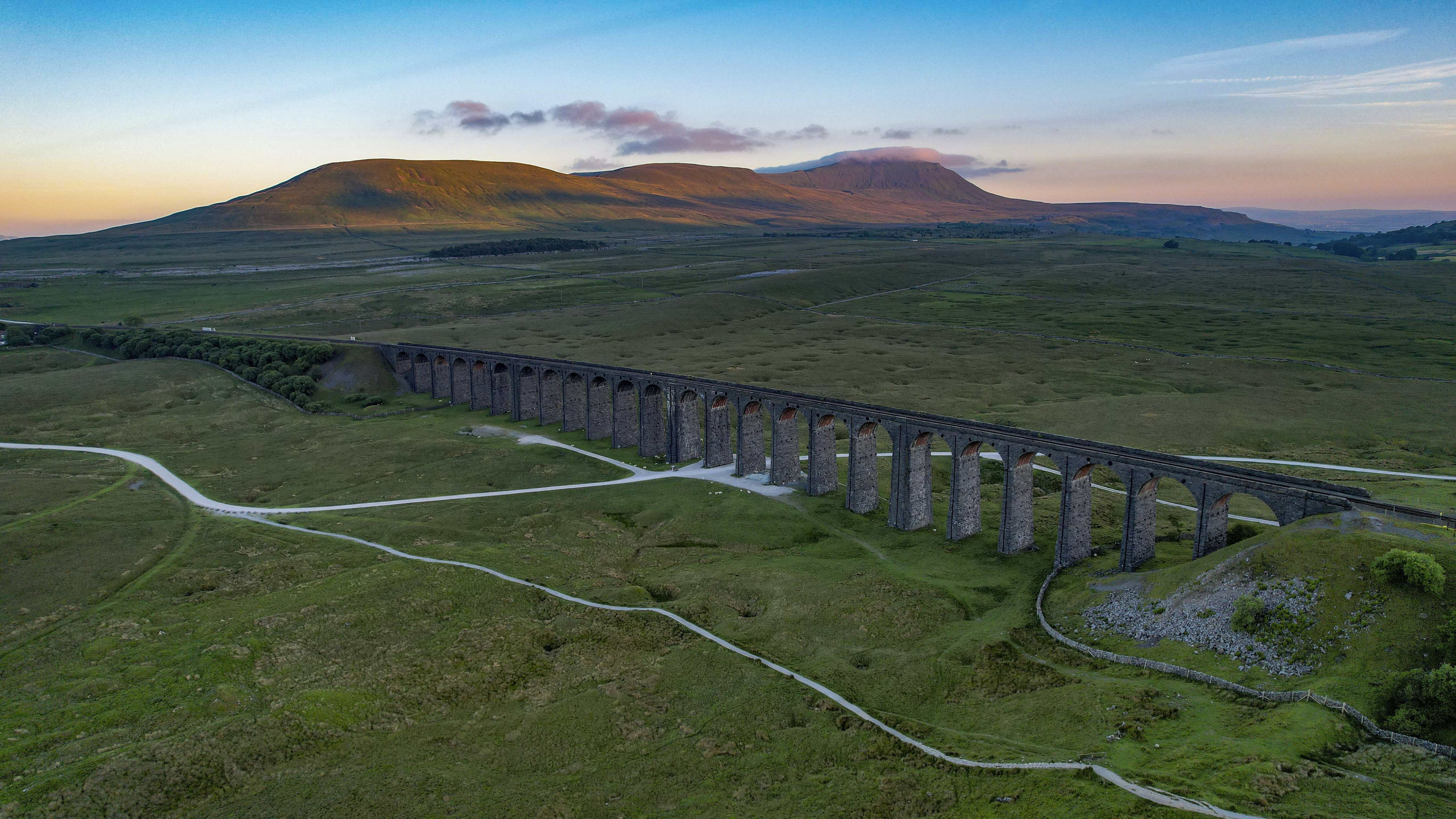 A large viaduct stretches across the scenic landscape.