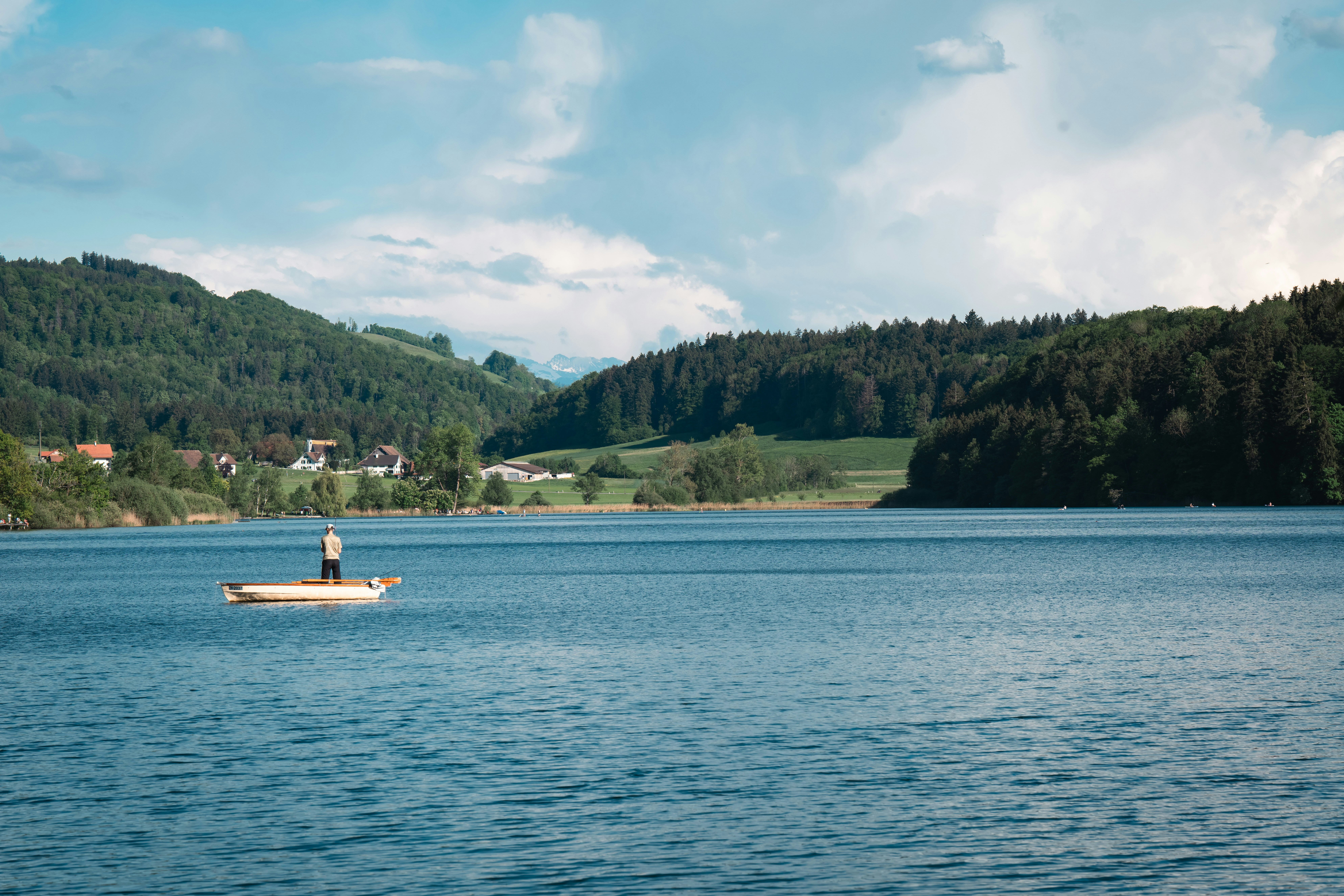 A person is on a boat in a beautiful lake.