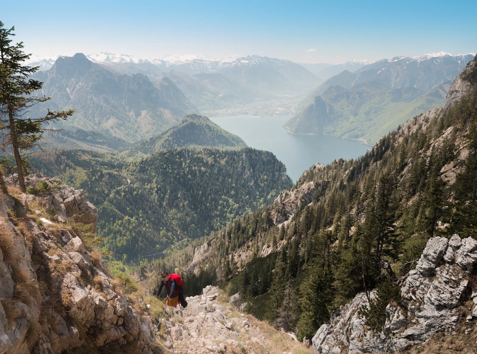 Randonneur sur un sentier de balcon rocheux dominant une vallée alpine &mdash; image d'illustration, non prise au Grand Balcon Sud