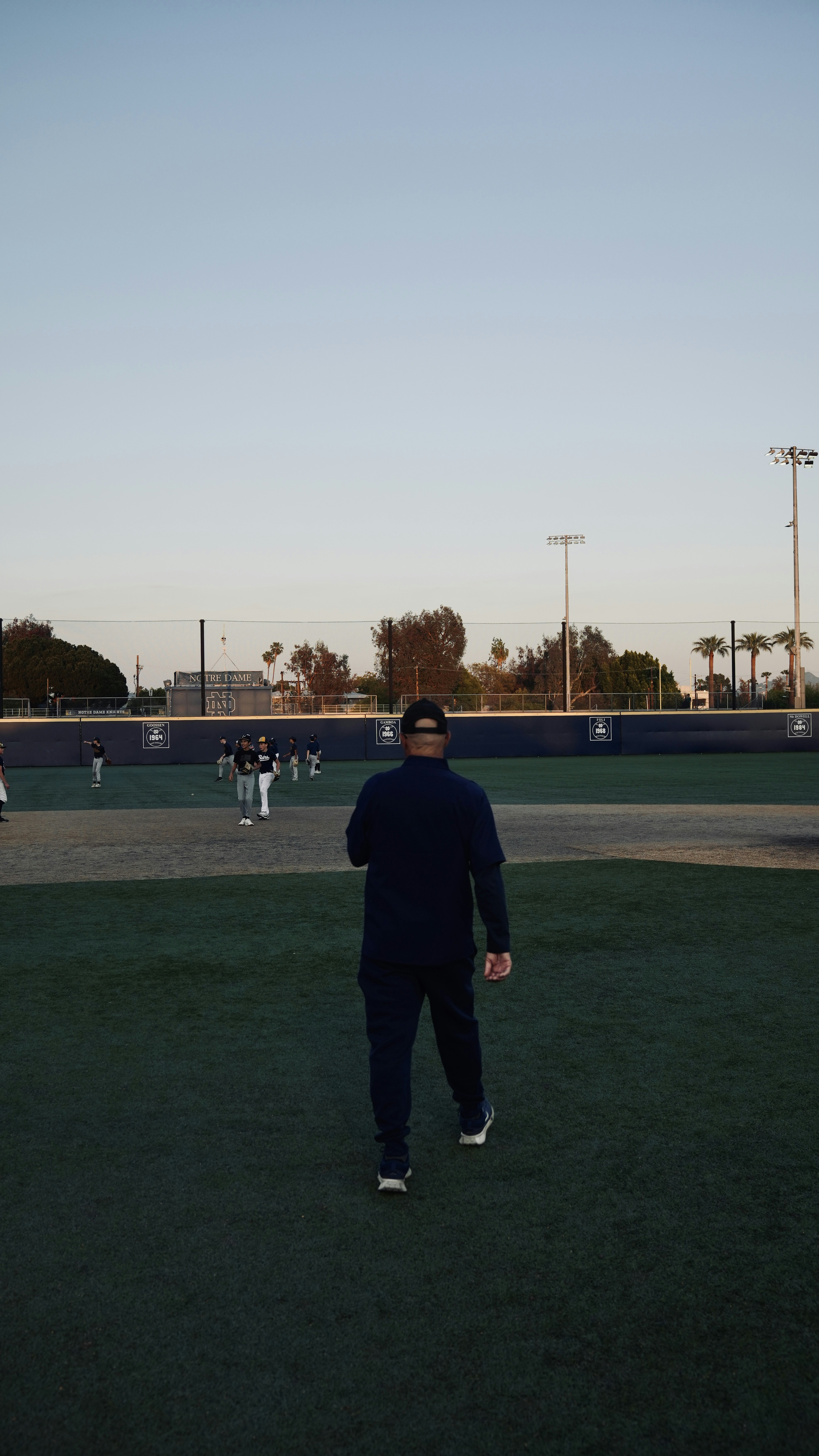 A coach walks toward his baseball team.