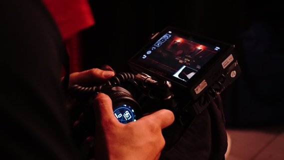 A photographer holds up a camera to film.