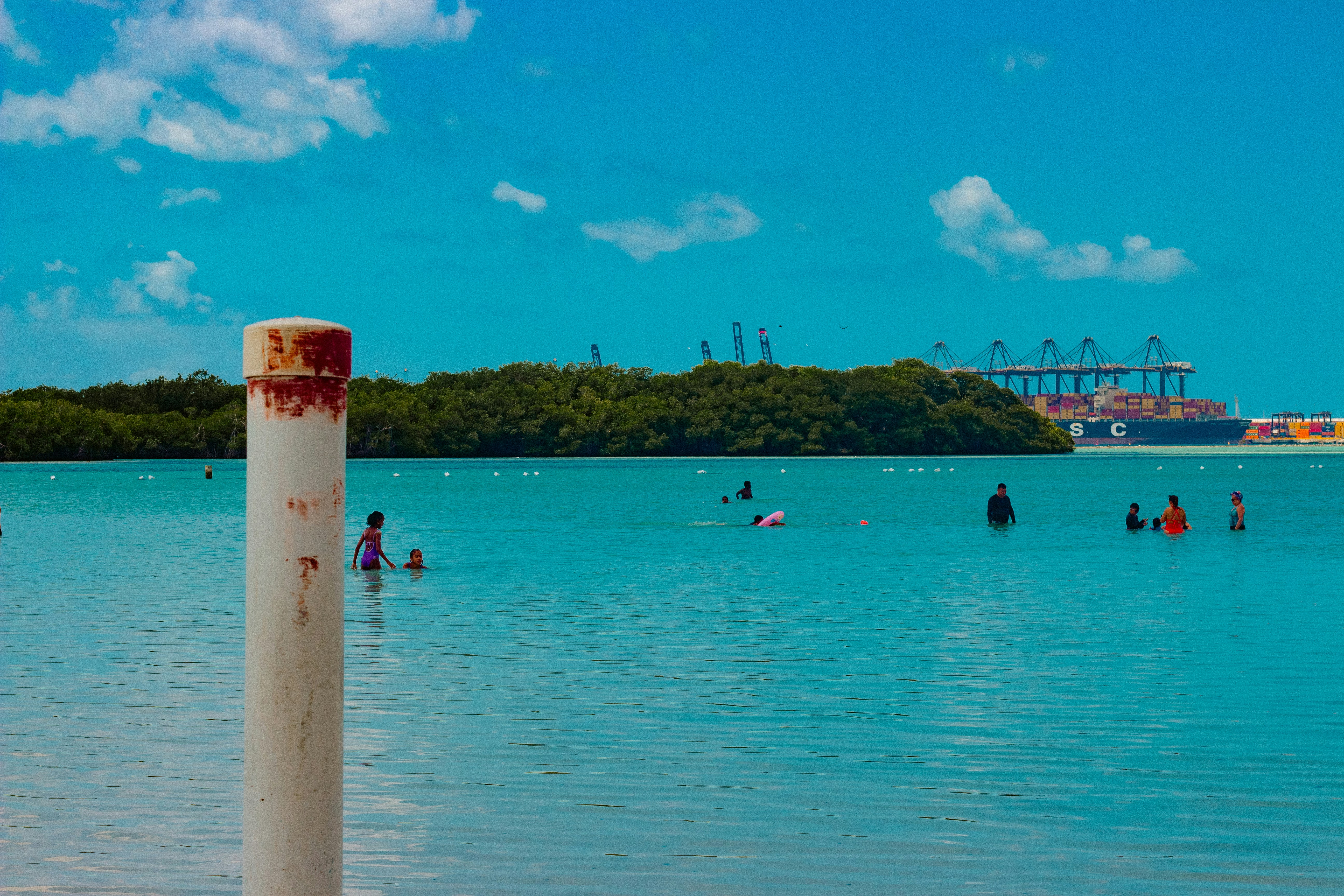 People swim in a beautiful, turquoise ocean.