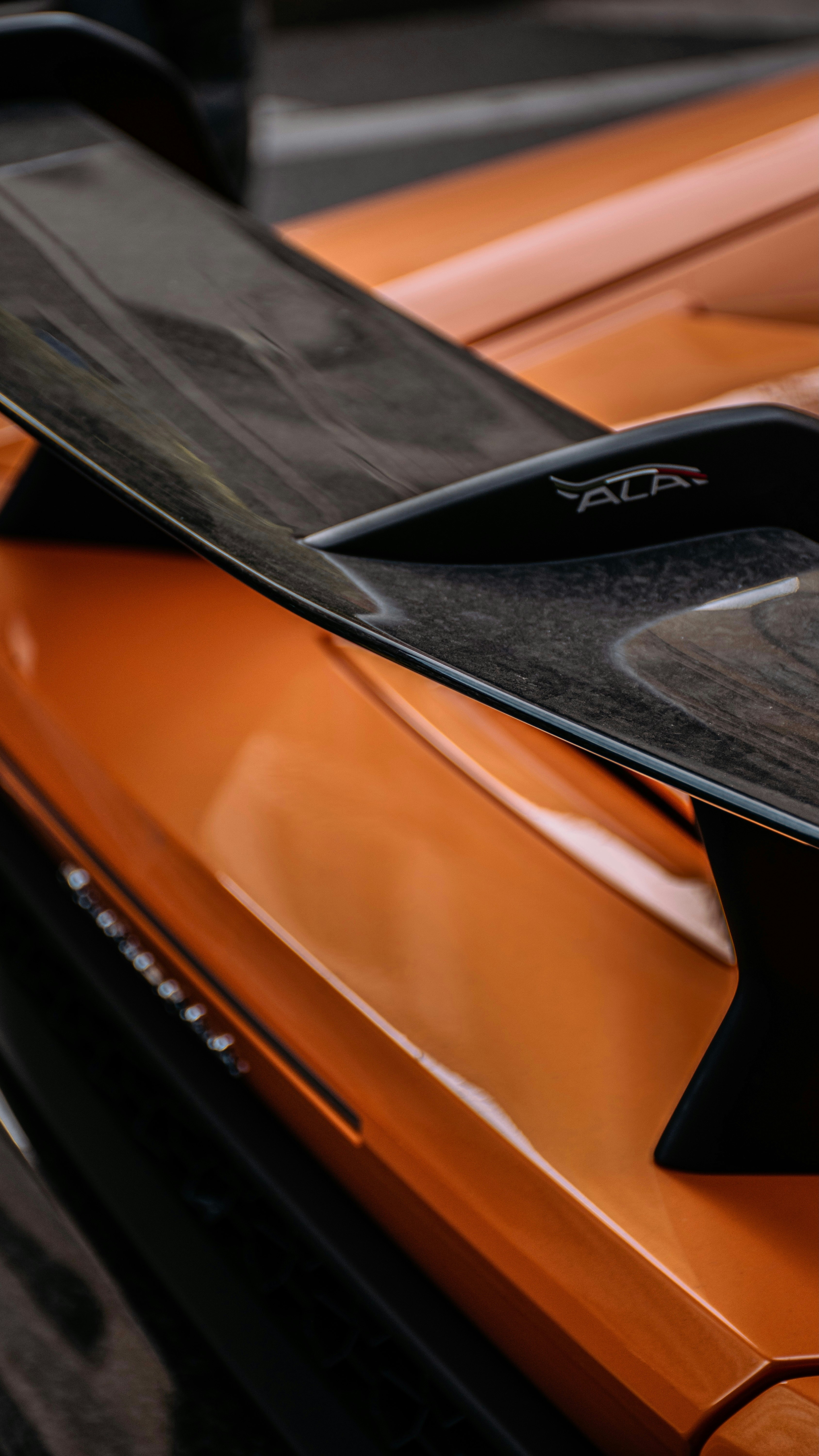 L’aileron et la carrosserie orange d’une voiture sont montrés.
