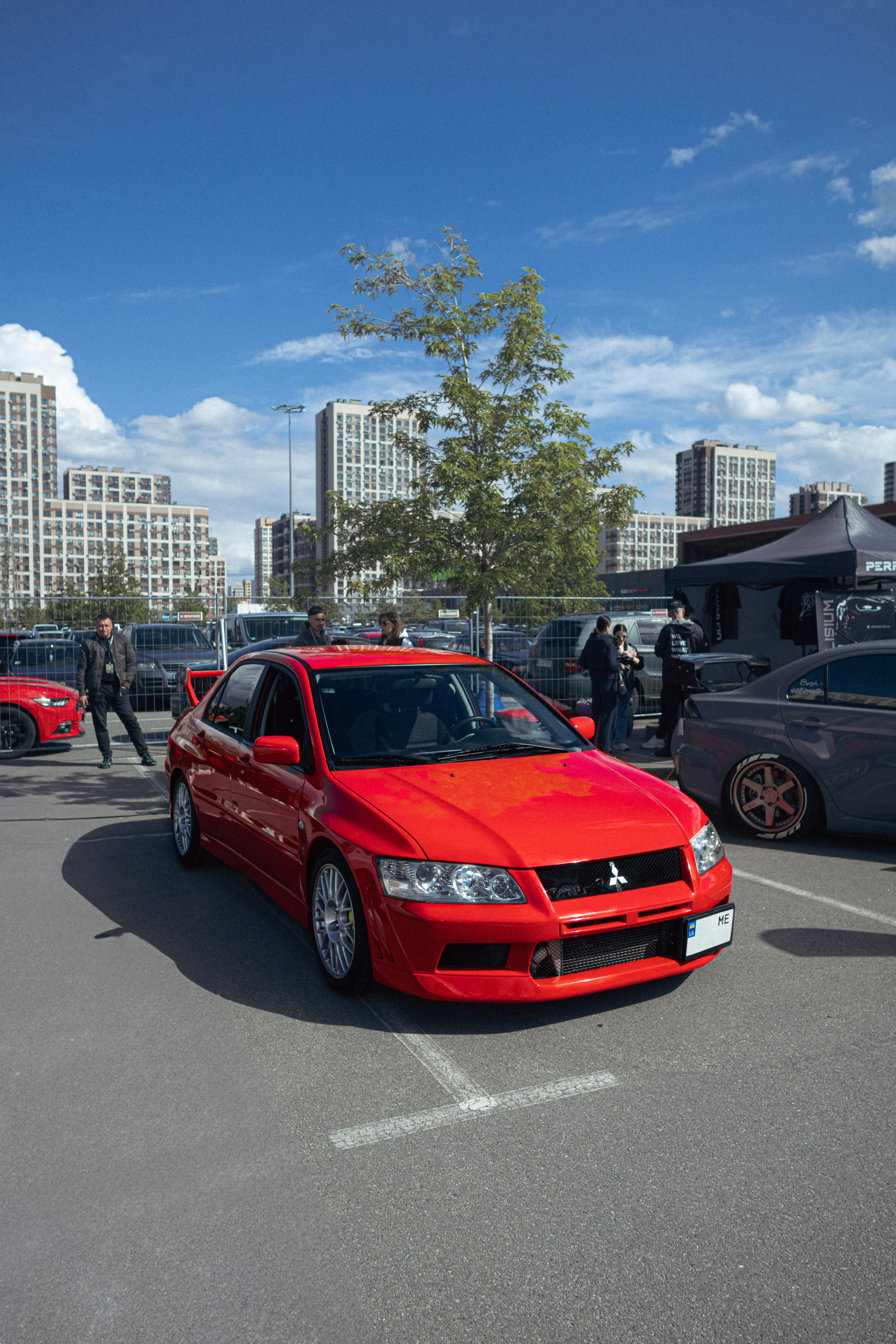 Ein knallrotes Auto, das an einem sonnigen Tag geparkt ist.
