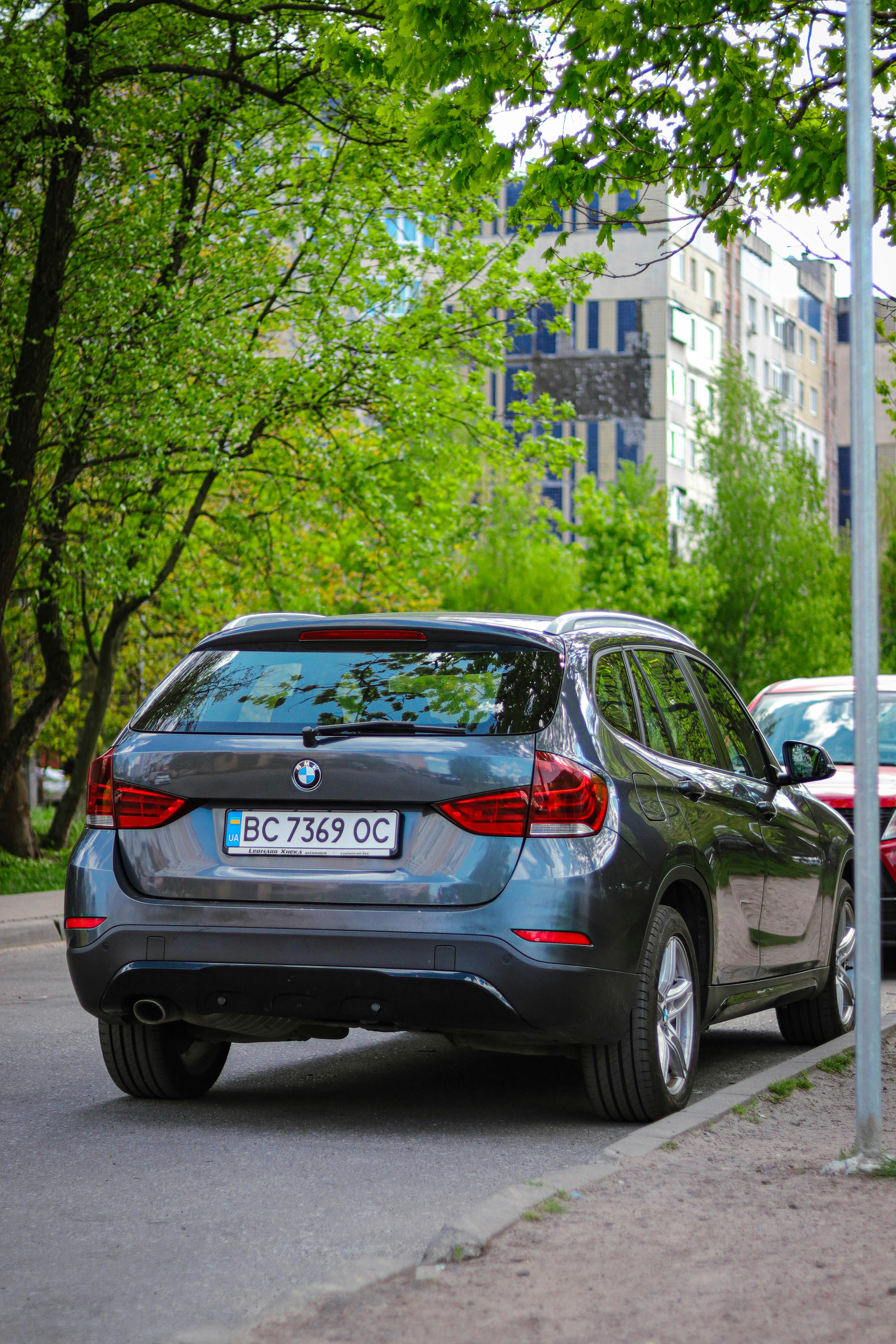 A gray BMW suv is parked on the street.