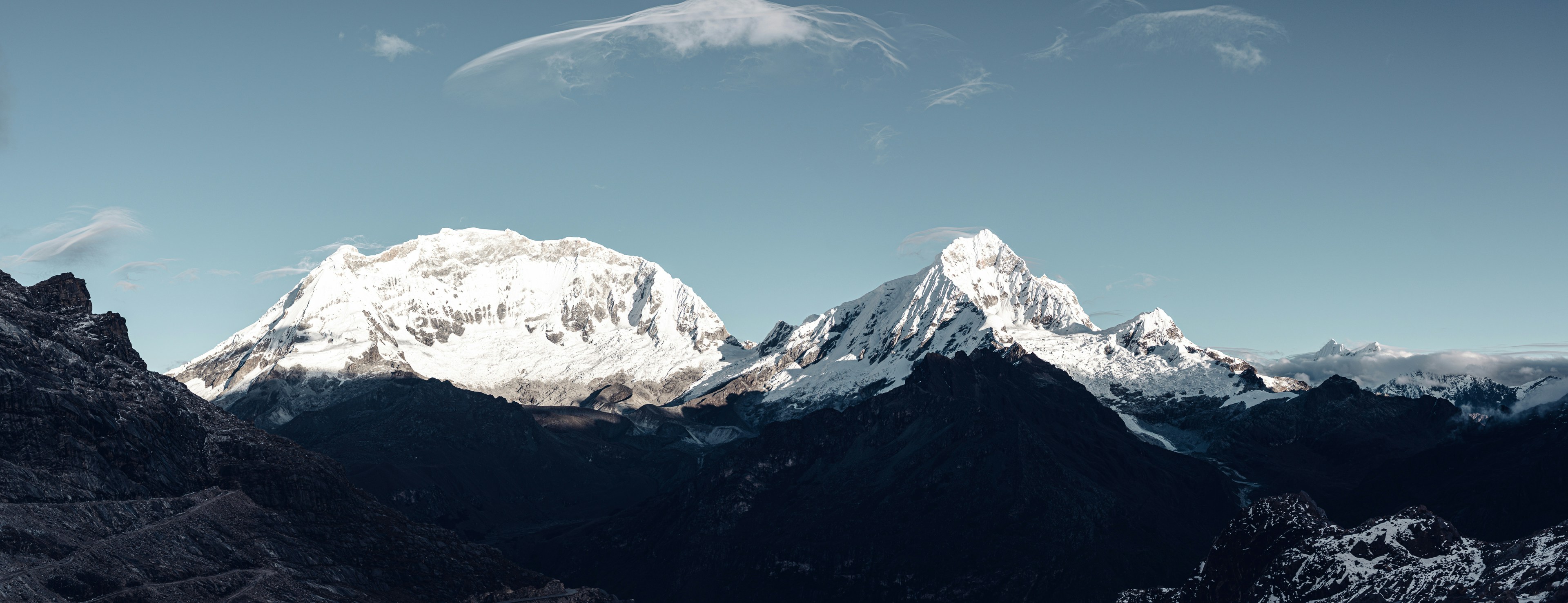 Verschneite Berggipfel unter strahlend blauem Himmel.
