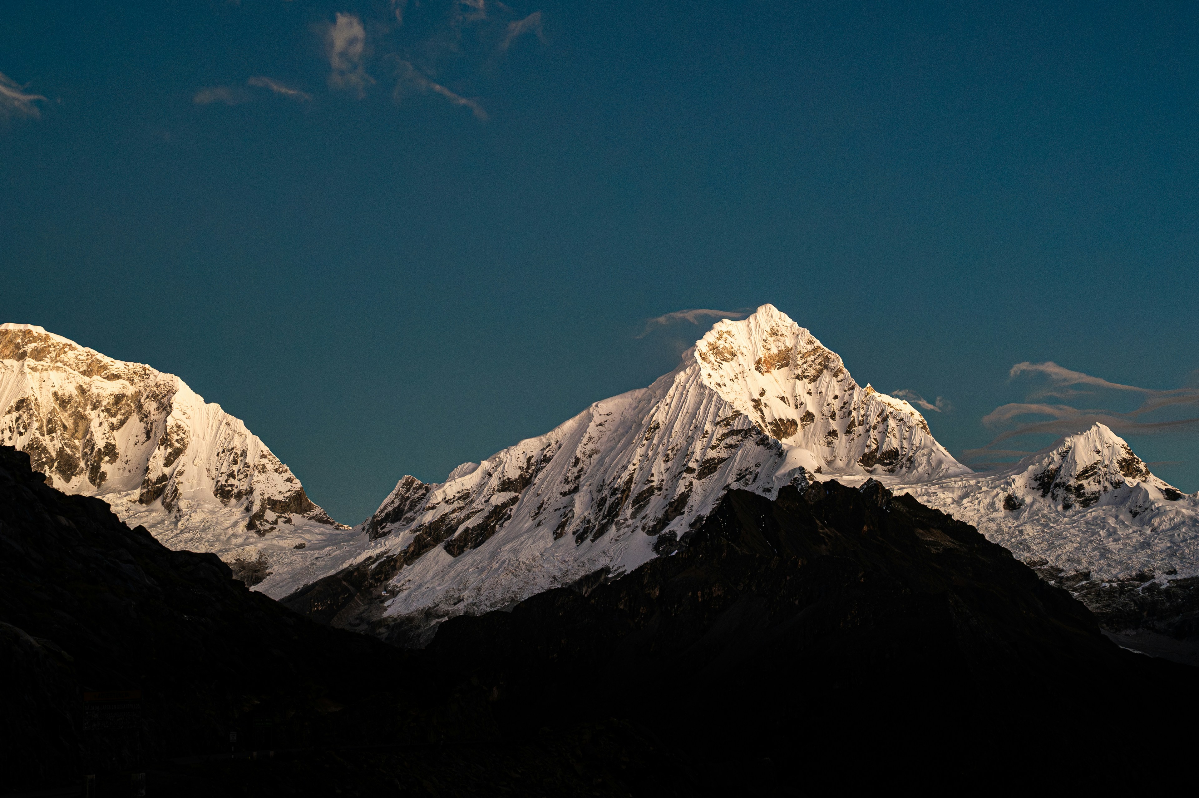Schneebedeckte Berge funkeln vor blauem Himmel.