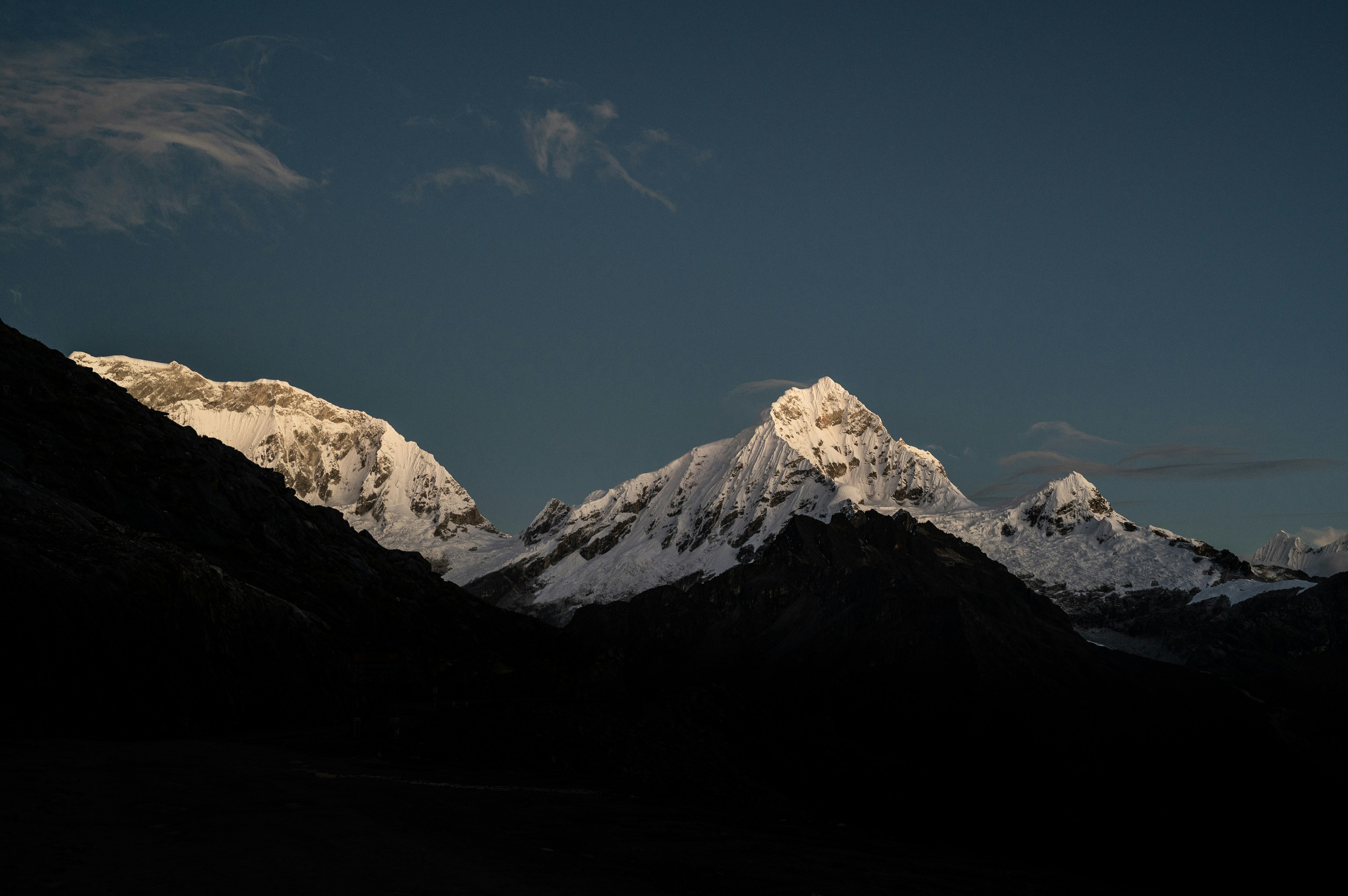 Verschneite Berge werden von der Sonne beleuchtet.