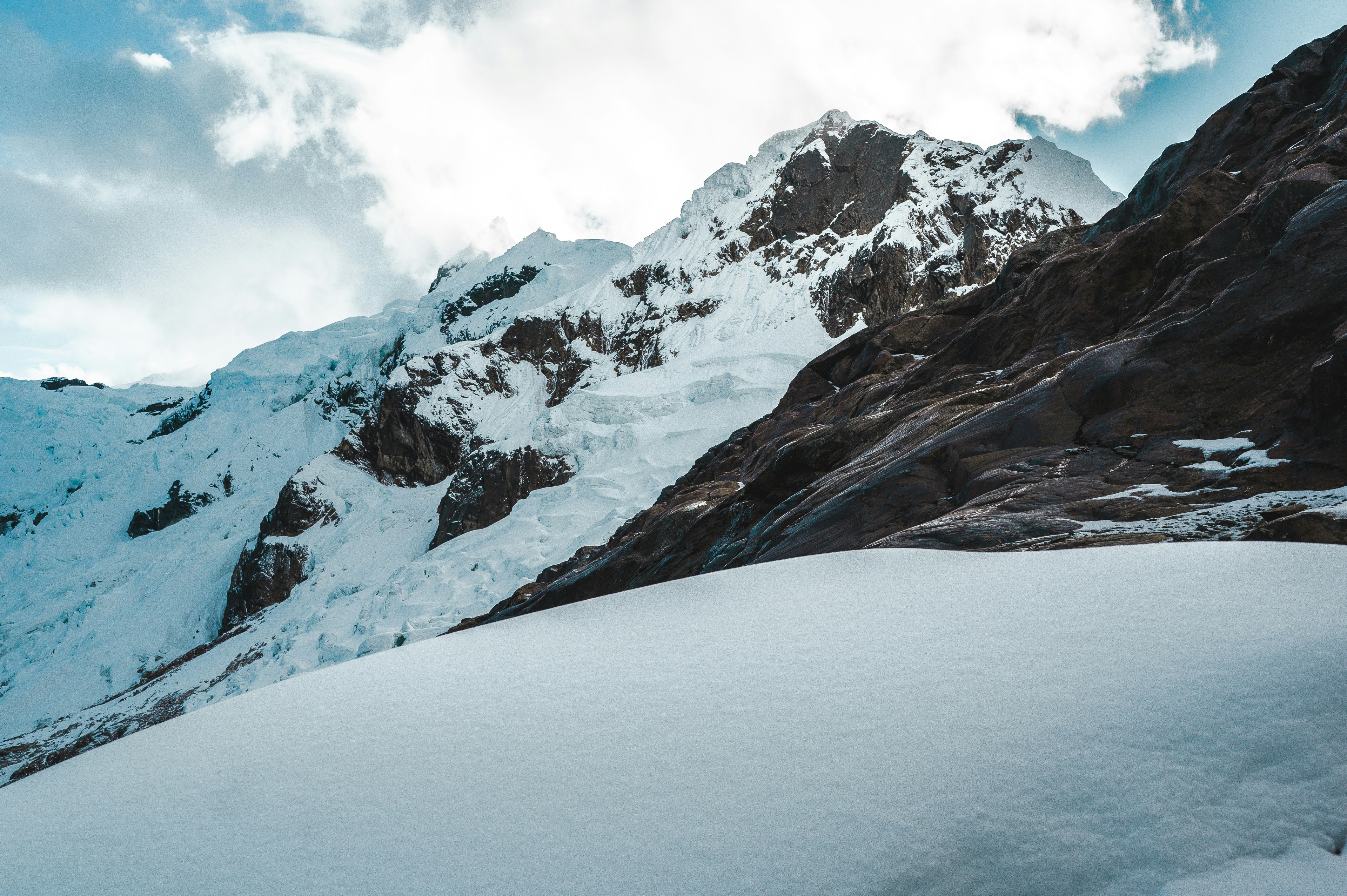Schneebedeckte Berge unter einem bewölkten Himmel.