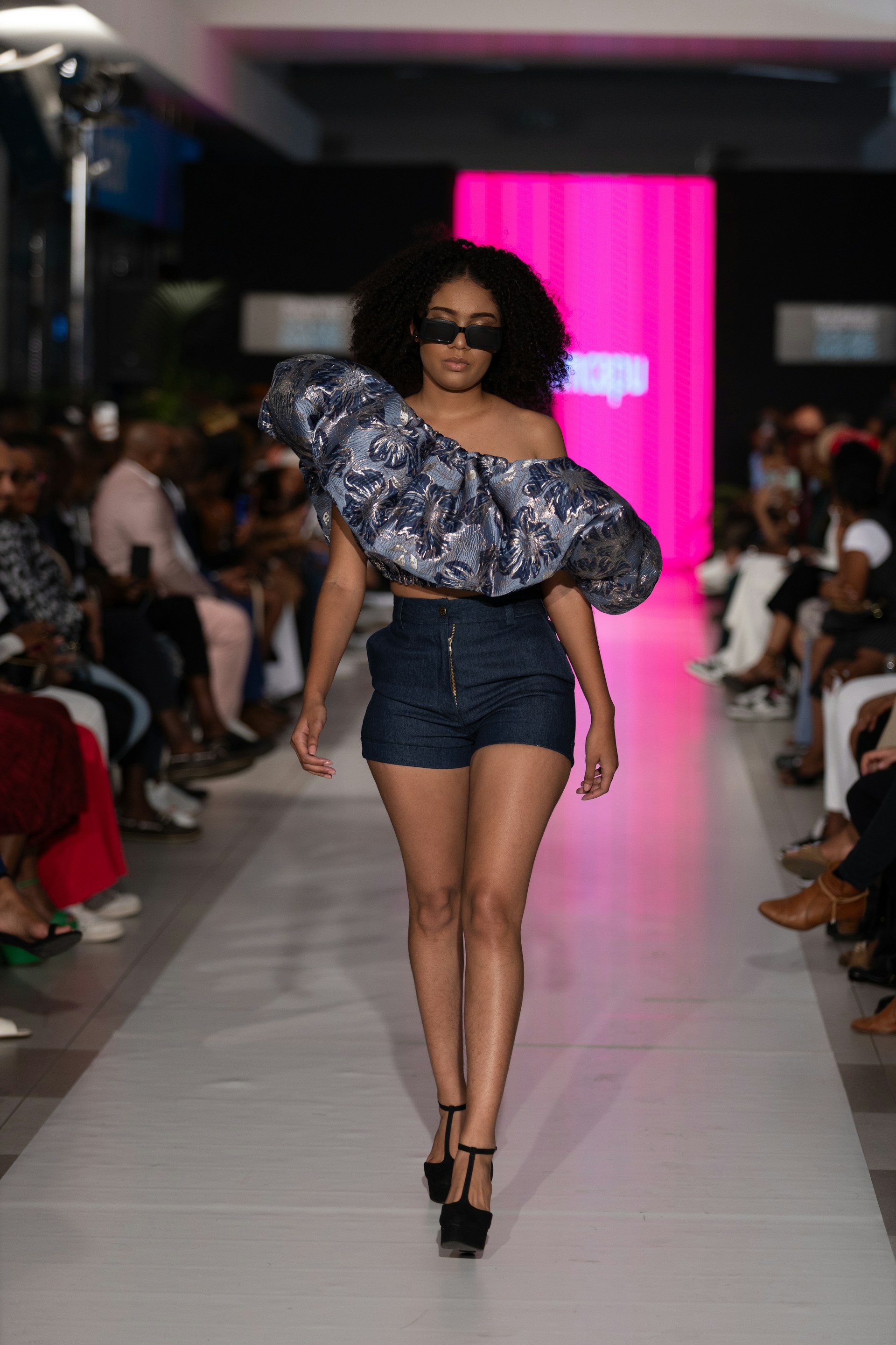 A model struts the runway wearing stylish clothing.