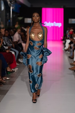 A model struts down a runway in a designer dress.