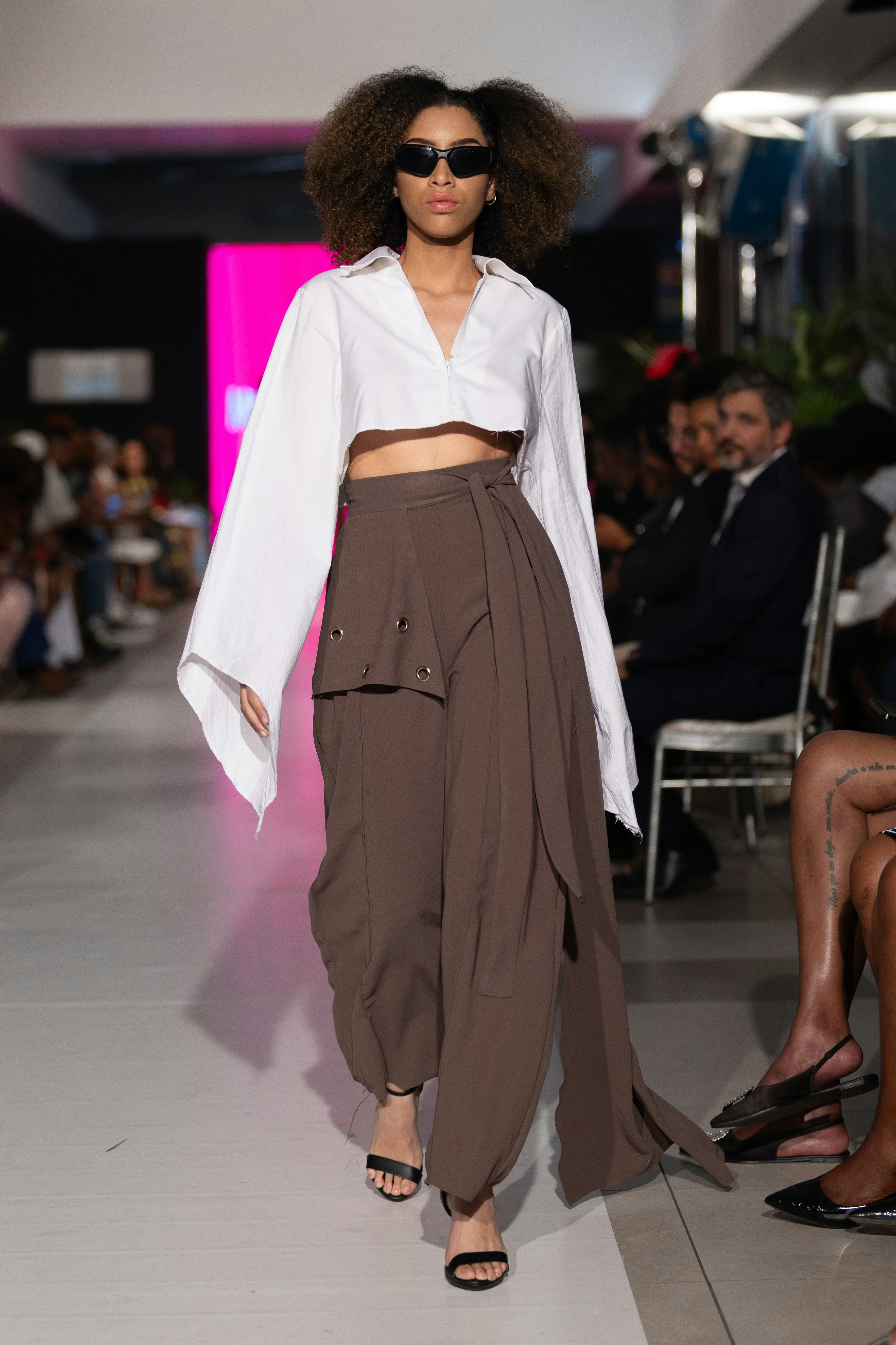 Model showcasing a modern fashion ensemble on a runway.