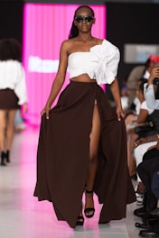 A model struts down the runway in stylish clothing.