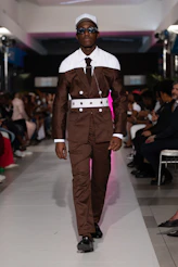 A model walks the runway in a brown suit.