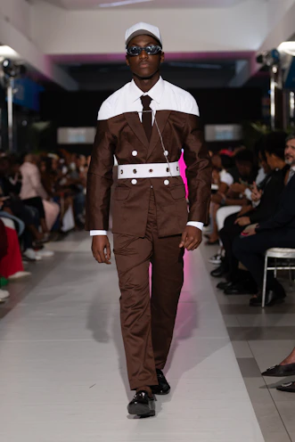 A model walks the runway in a brown suit.