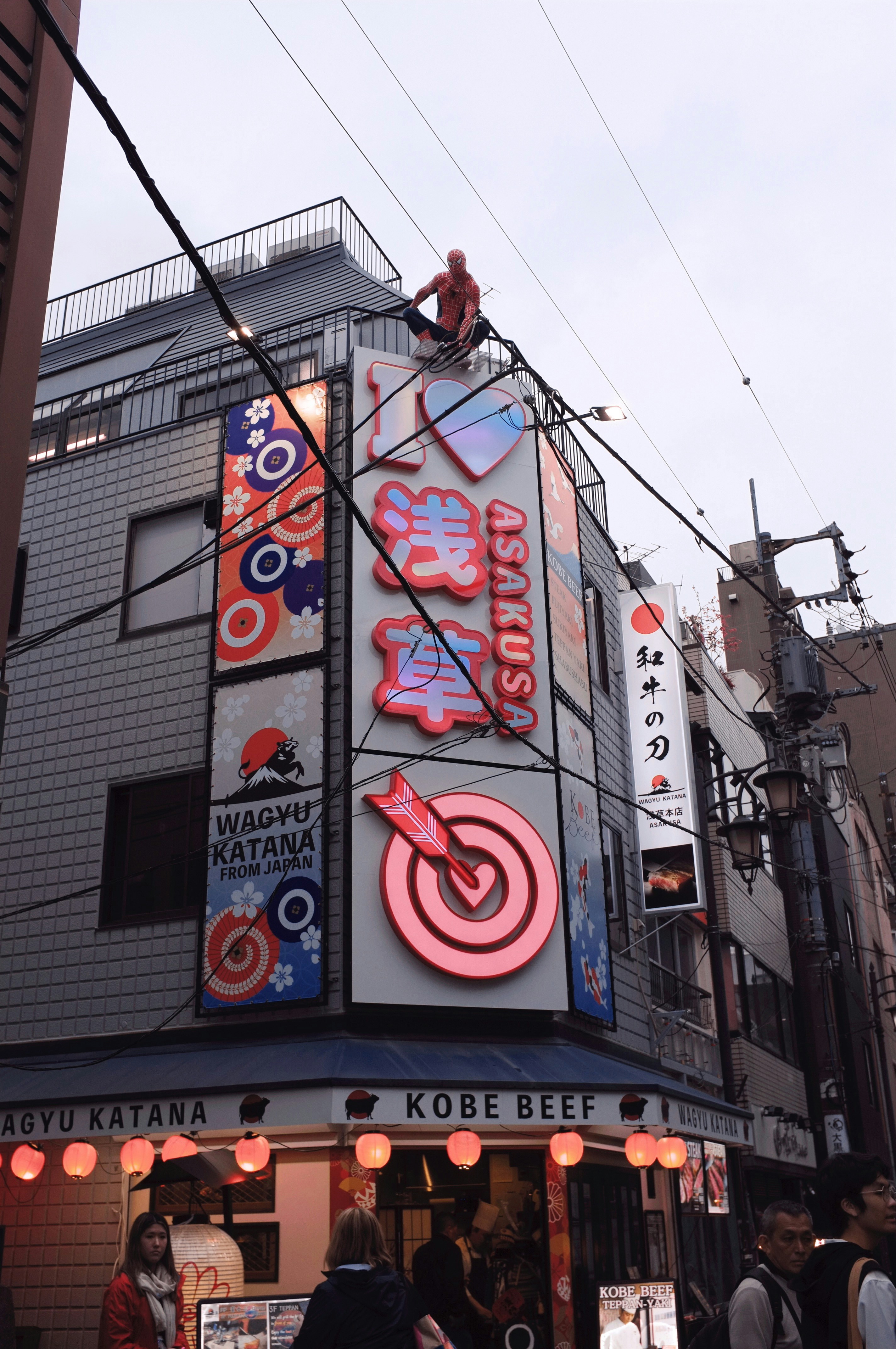 A restaurant with bright signs and a person on top.