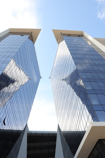 Two tall skyscrapers reflect the sky above.