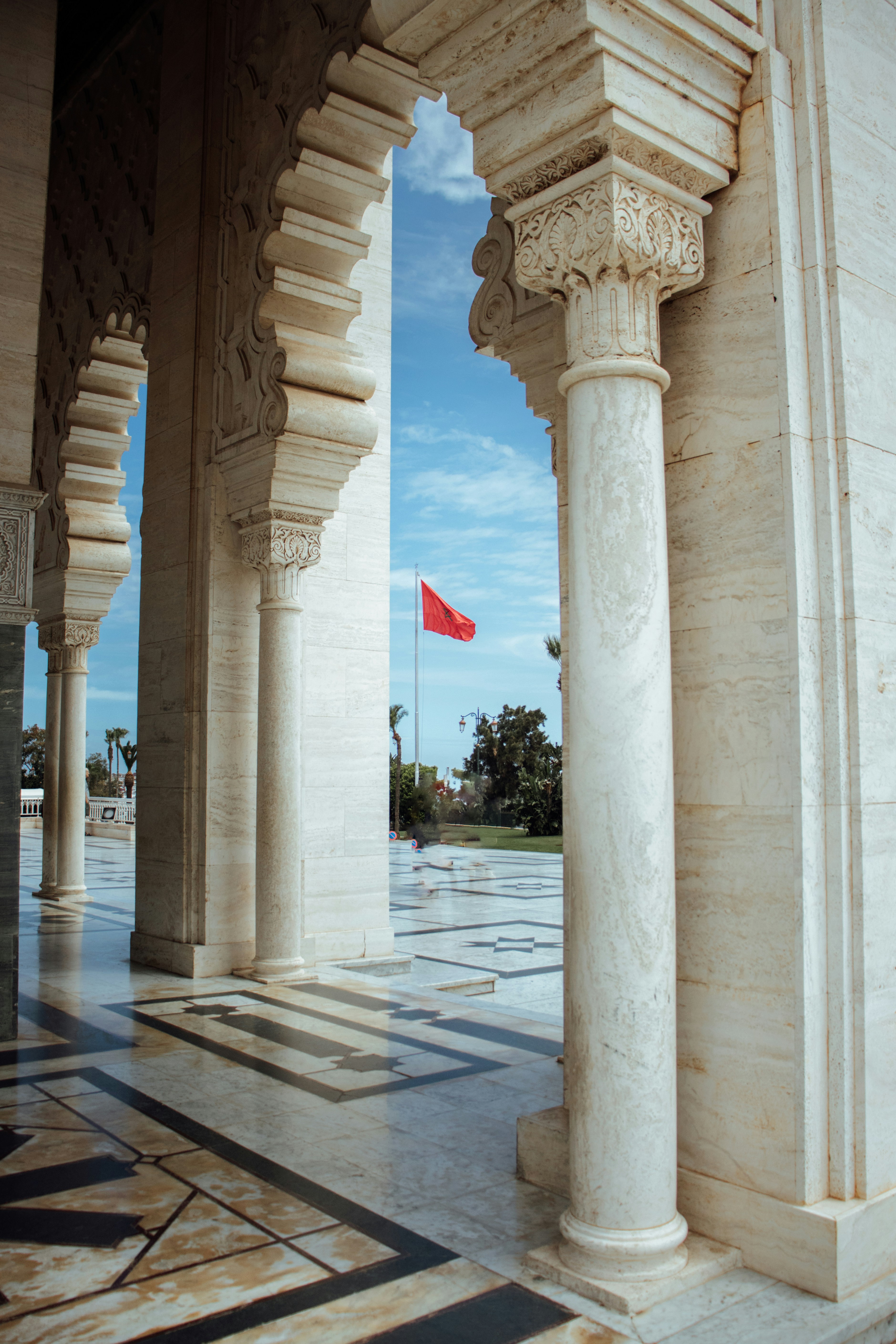 Ornate columns frame a view of a red flag. photo – Free Building Image ...