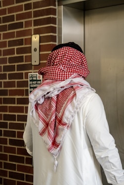 A man in traditional clothing enters an elevator.