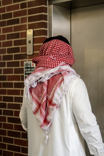 A man in traditional clothing enters an elevator.
