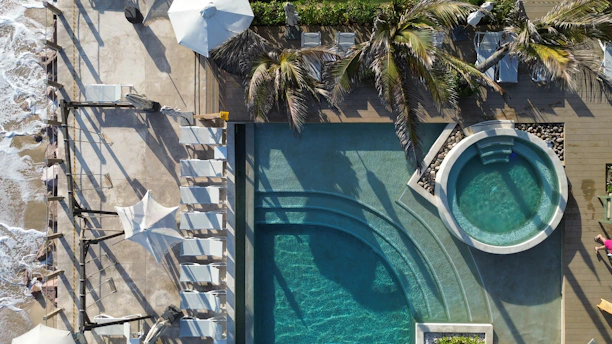 Aerial view of a beach resort's pool and jacuzzi.