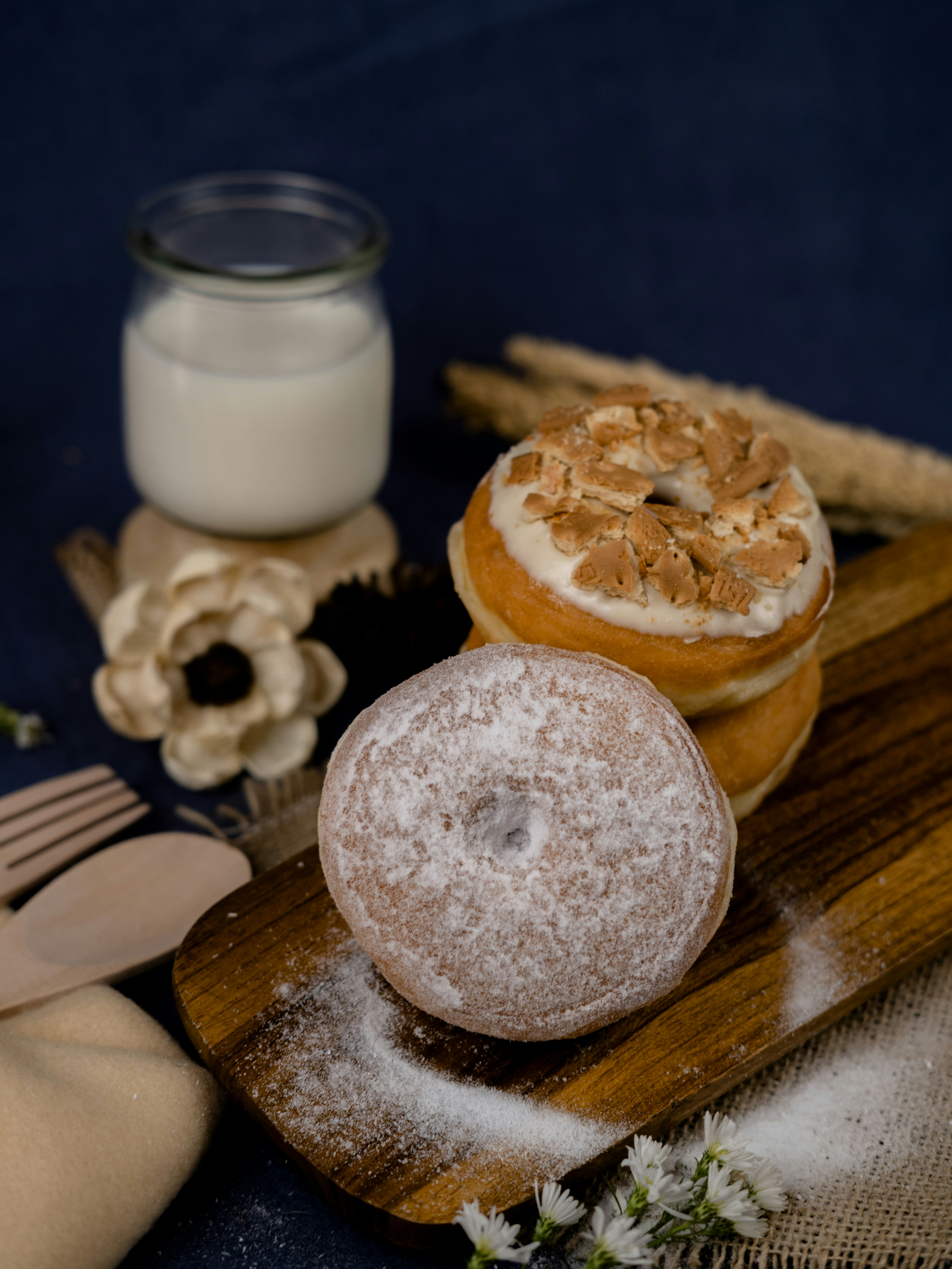 Delicious donuts and a glass of milk are pictured.