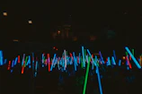Many glowing light sticks fill the dark space.