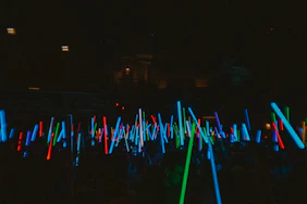 Many glowing light sticks fill the dark space.