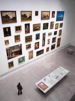 An art gallery displays many paintings on the wall.