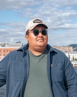 A man wearing sunglasses looks away from the camera.