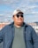 A man wearing sunglasses looks away from the camera.