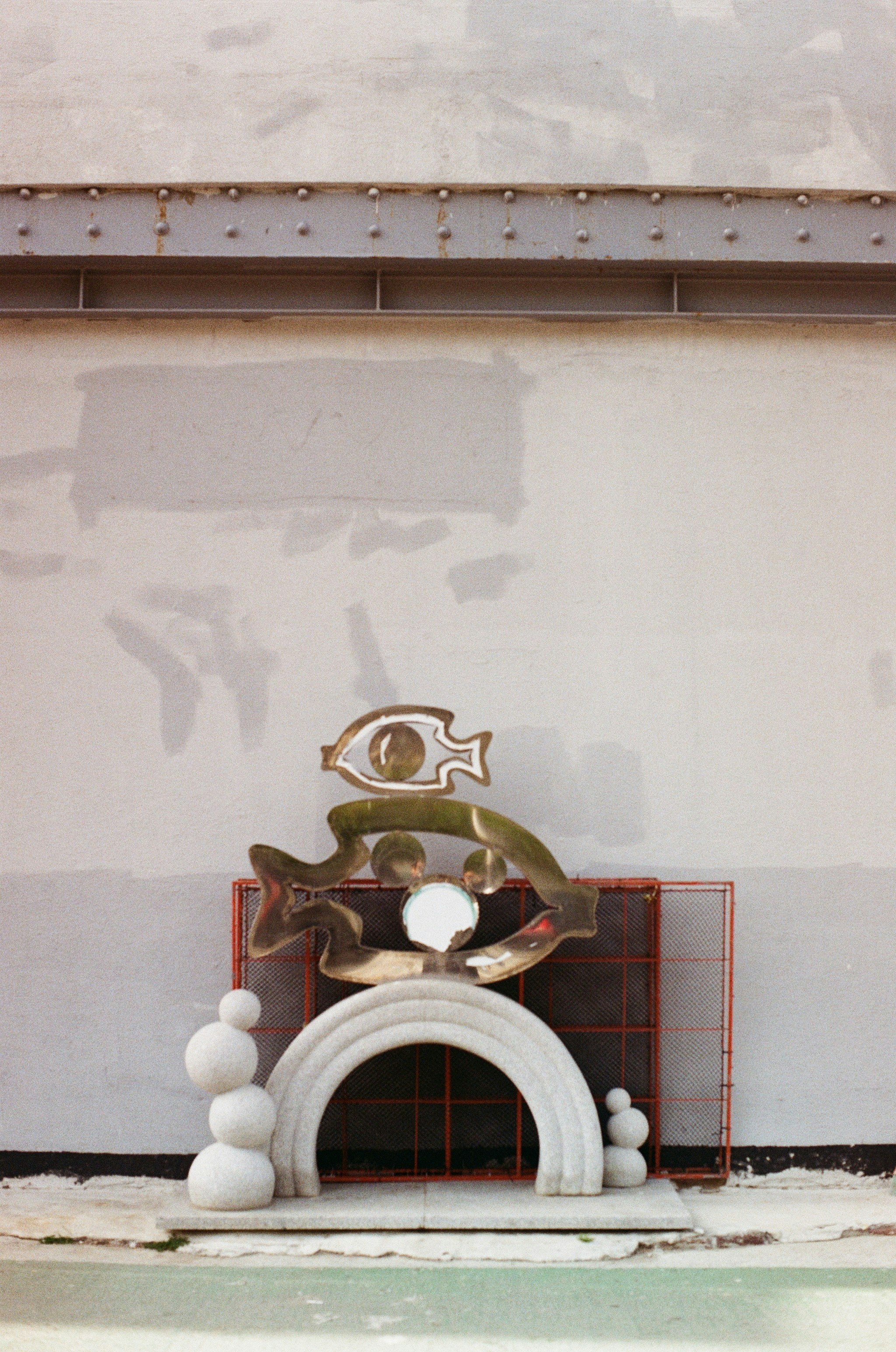 Sculptures and abstract art displayed against a gray wall.