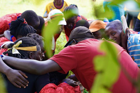People of diverse backgrounds share a warm embrace.