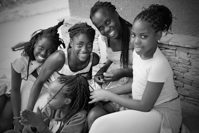 Five smiling girls pose together for a photo.