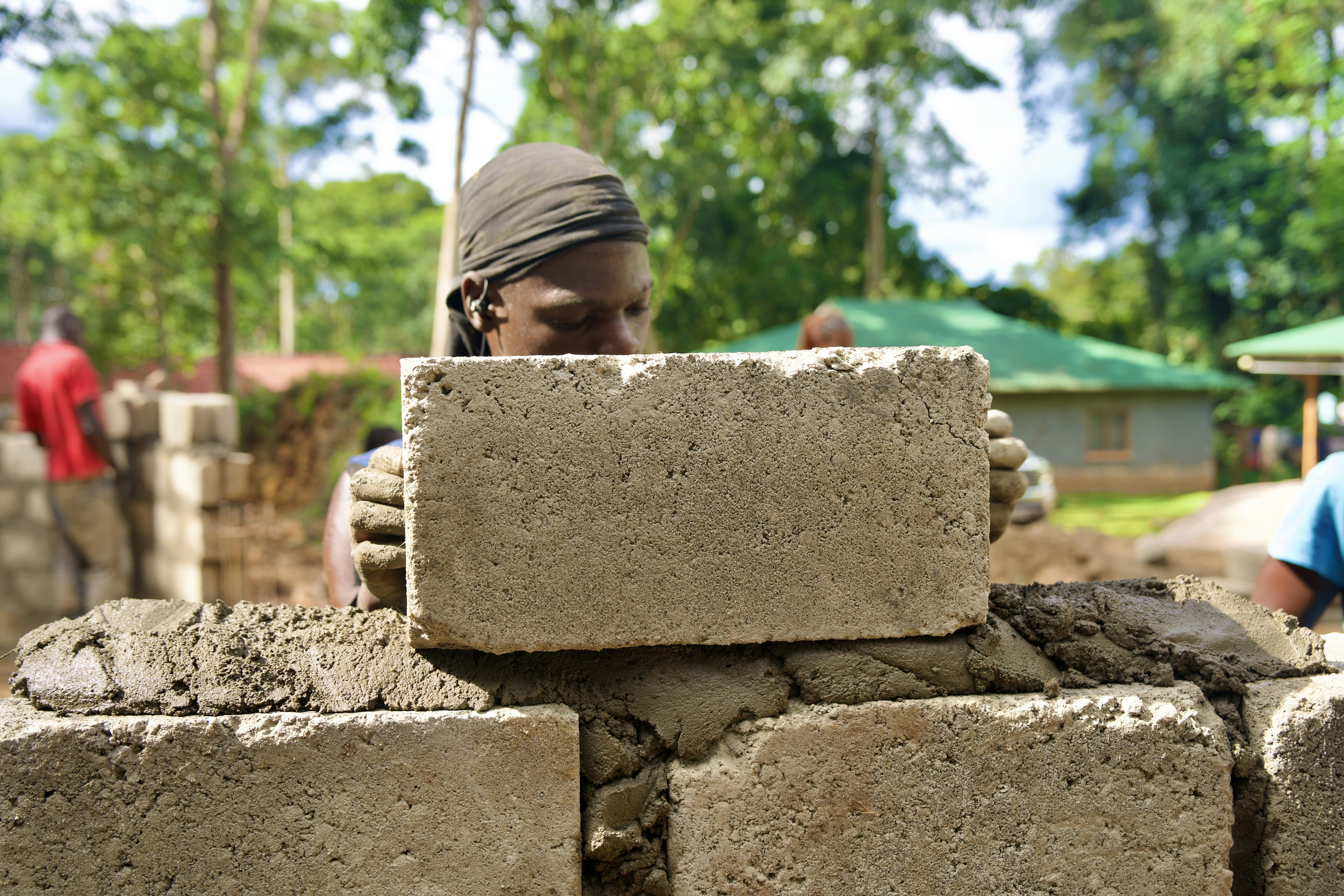 A person is building a wall with concrete blocks.