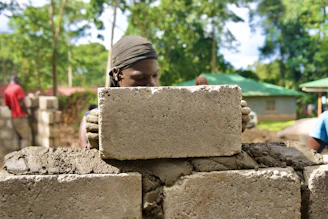 A person is building a wall with concrete blocks.