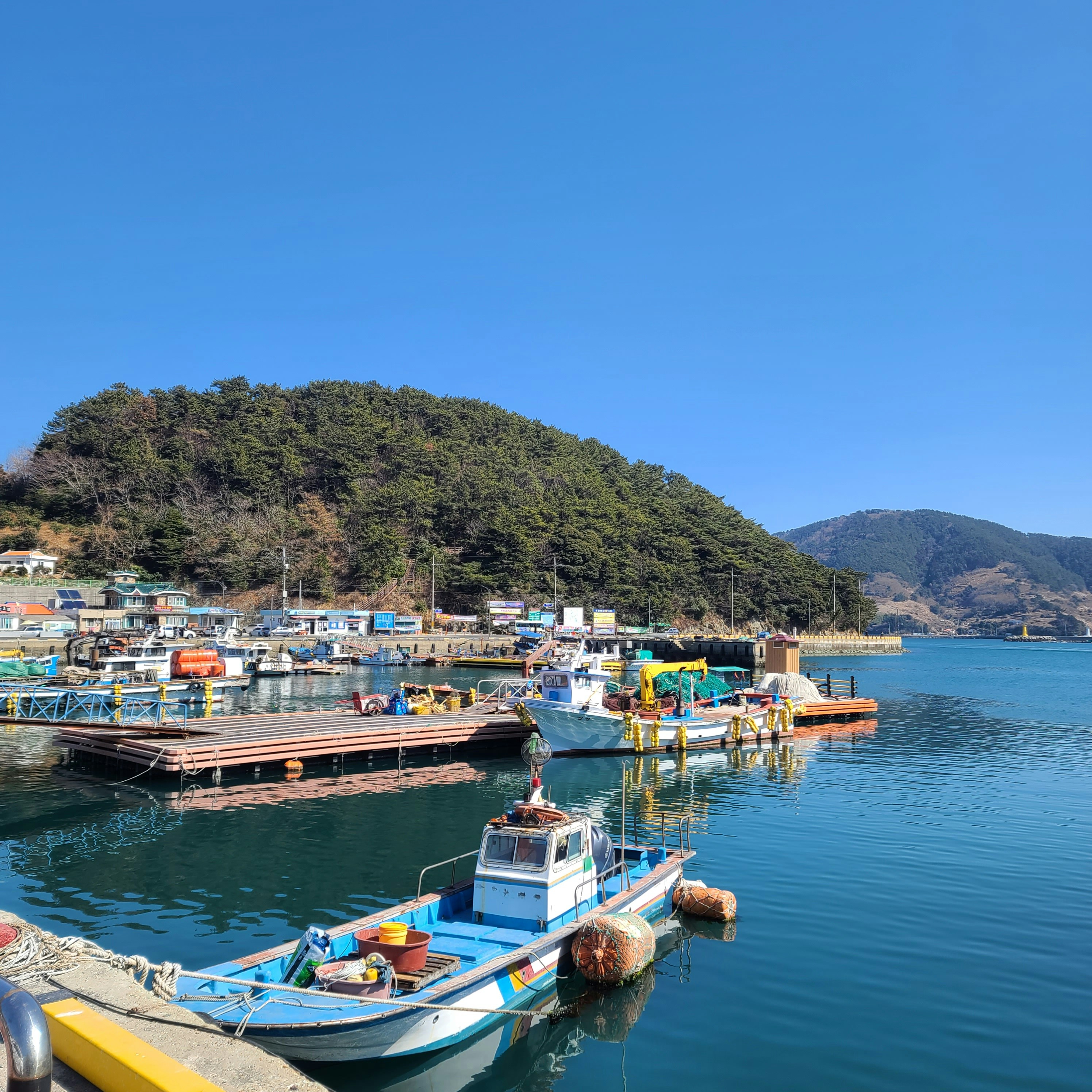 Boats are docked at a serene seaside harbor.