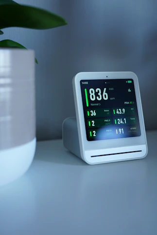 Air quality monitor displays pollution readings on a screen.