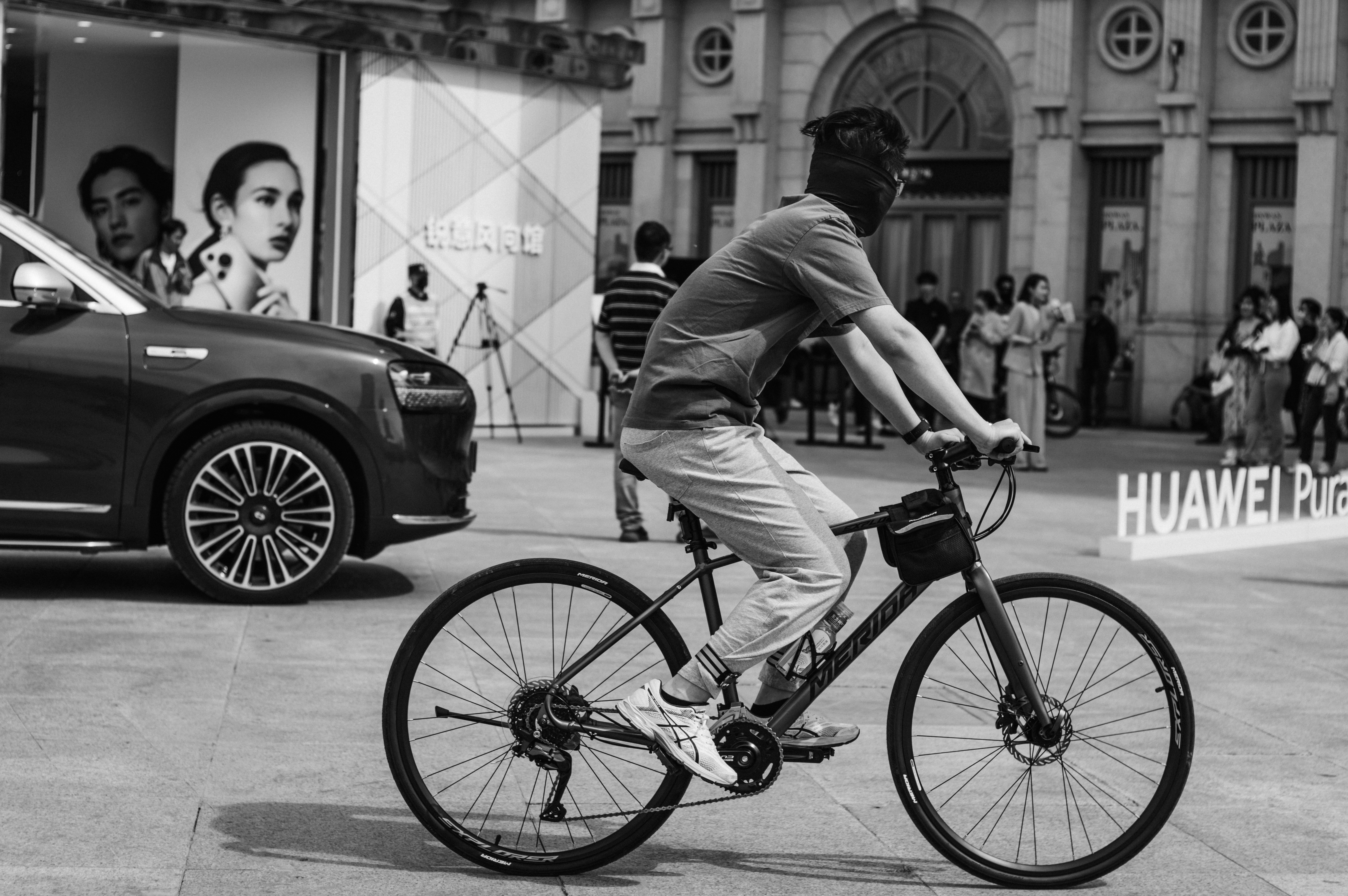 Un hombre anda en bicicleta cerca de un coche.