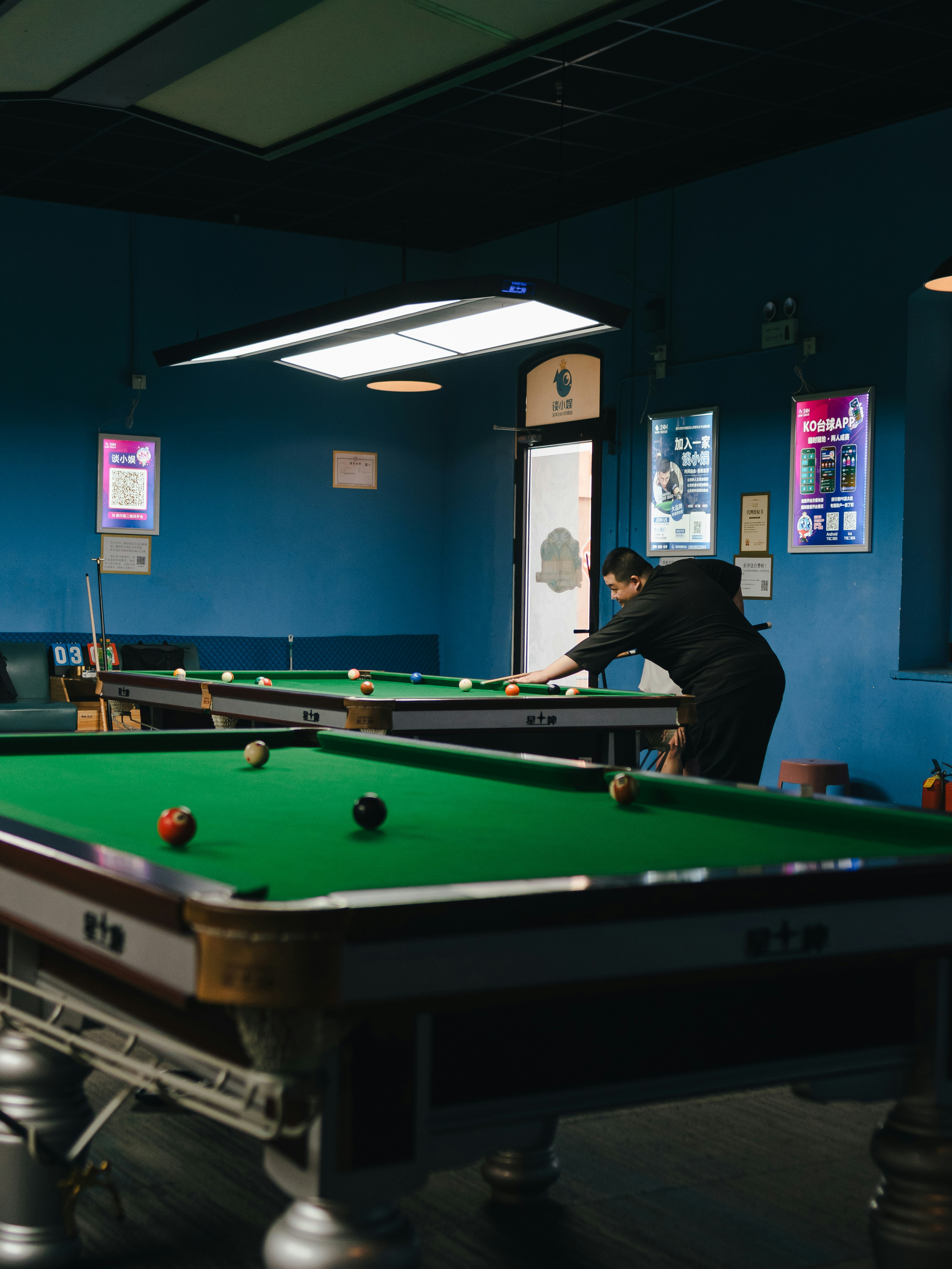 Una persona está jugando al billar en una sala de billar.