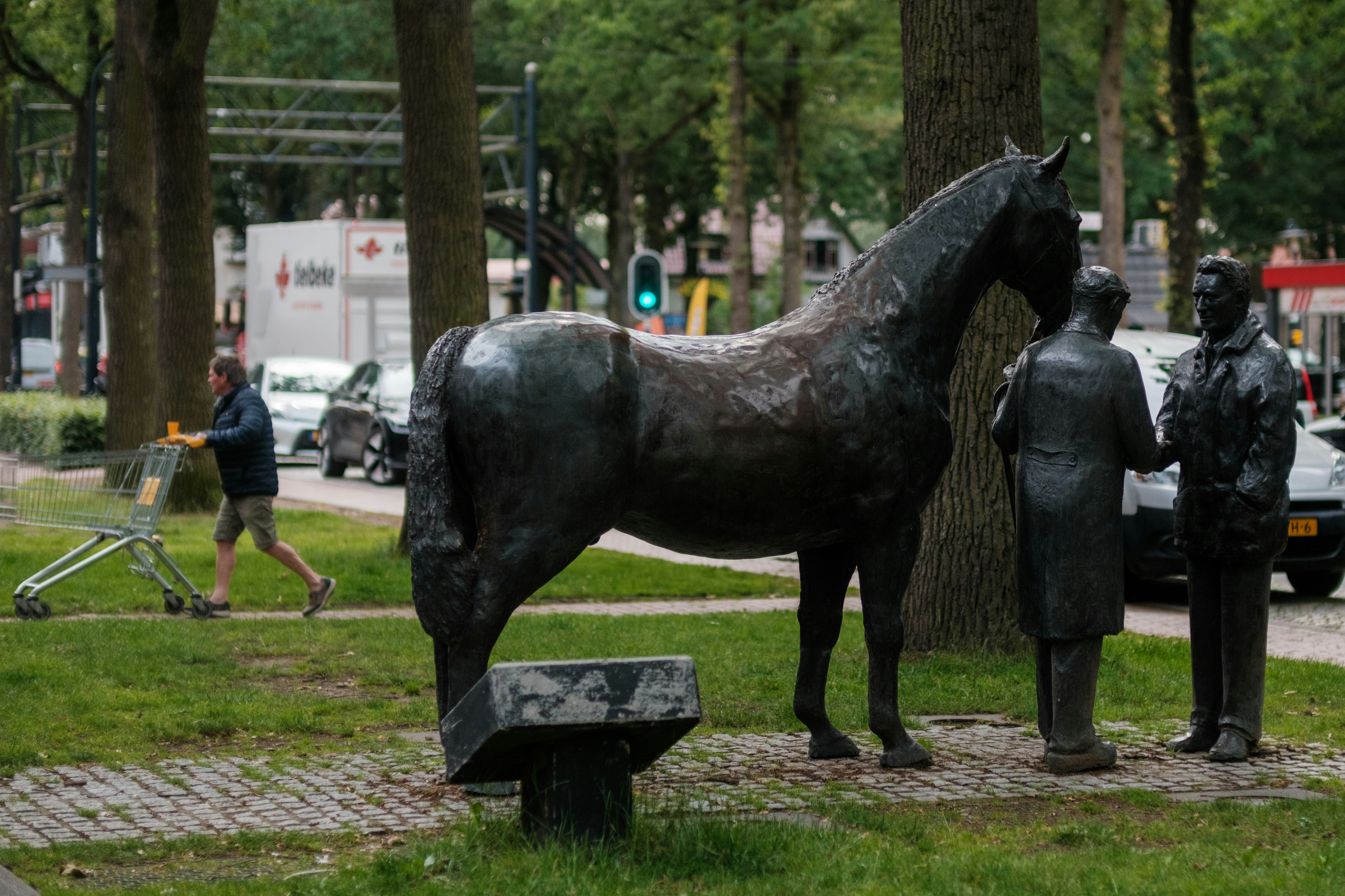 A bronze horse statue stands with two figures.