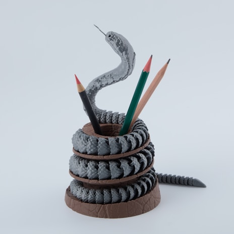 A snake pencil holder with pencils.